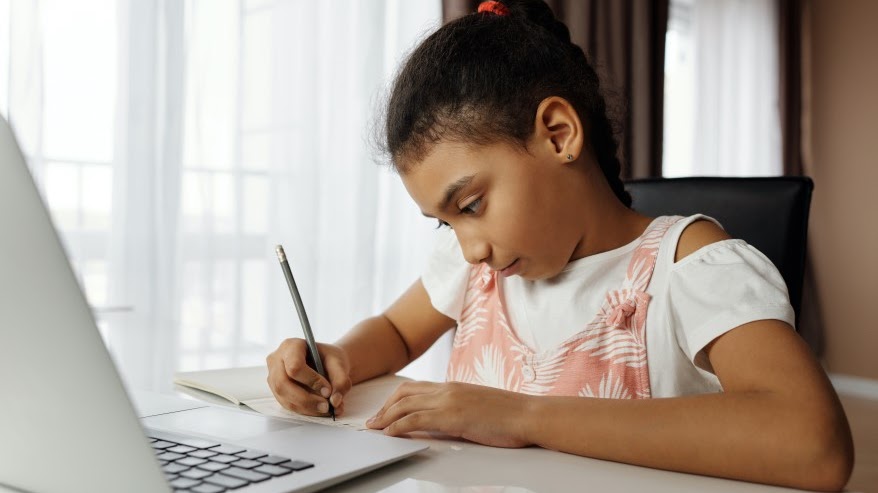 Student with pencil in front of computer