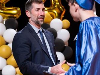 student shaking director hand