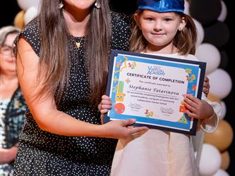 student posing with diploma