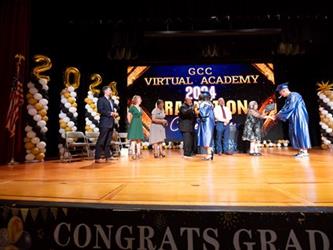 students on stage getting diploma