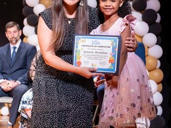 student posing with diploma