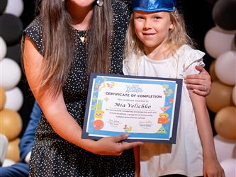 student posing with diploma