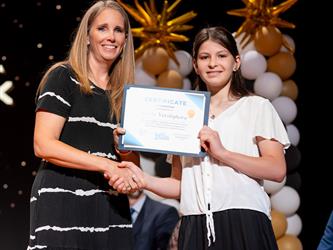 student posing with diploma
