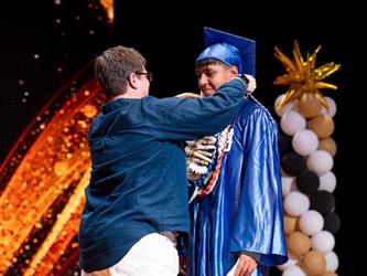students receiving diploma on stage