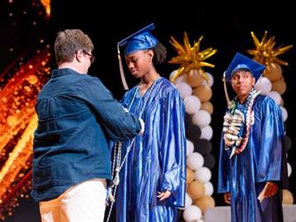 students receiving diploma on stage