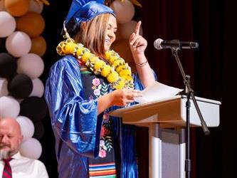 graduate speaking at podium